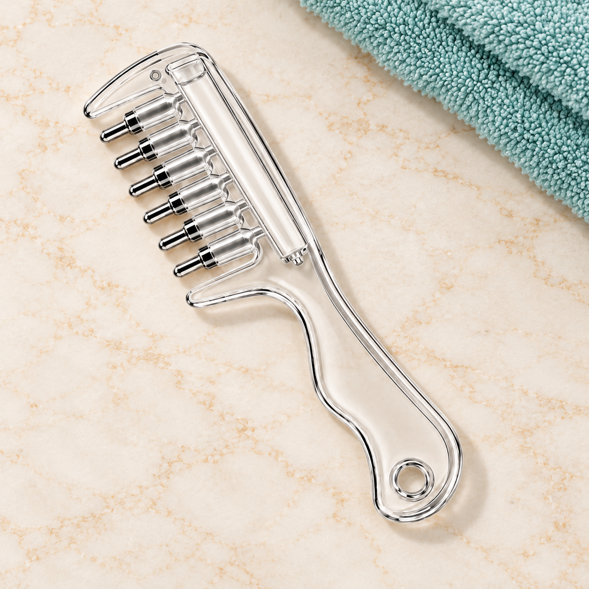 Clear scalp applicator comb resting on a vanity beside a towel